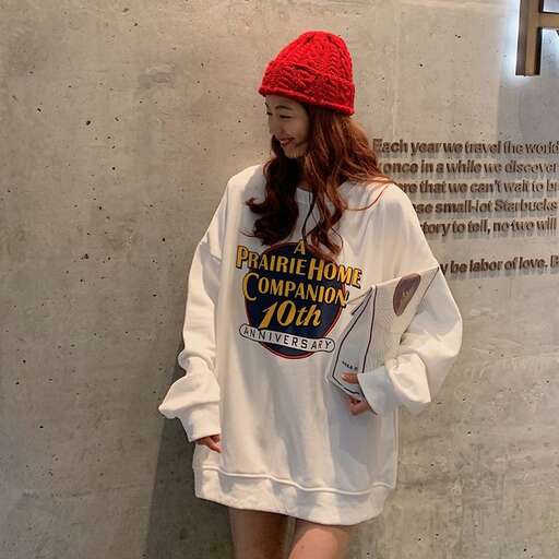 a model wears a white t - shirt and skirt with a red hat.