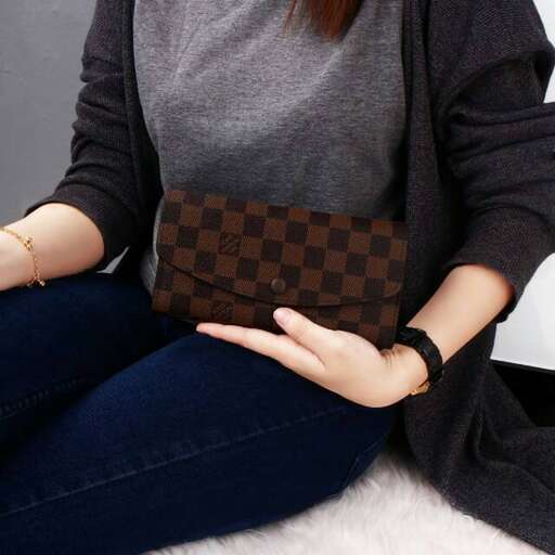 a woman holding a purse in her lap.