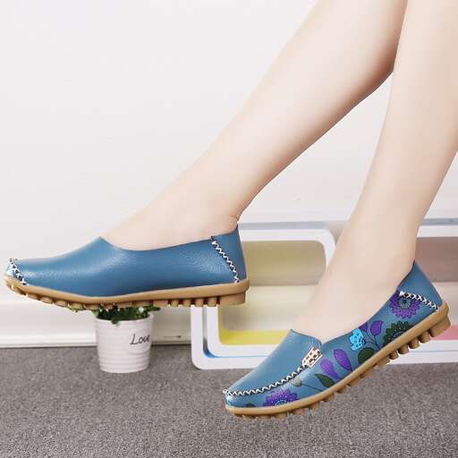 a woman's blue flat shoes with floral print