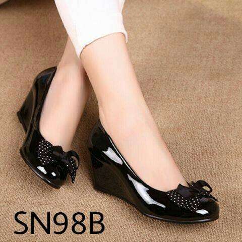 a woman's black flat shoes with a white stripe.