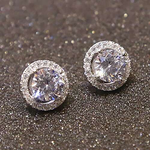 a pair of diamond earrings, by person