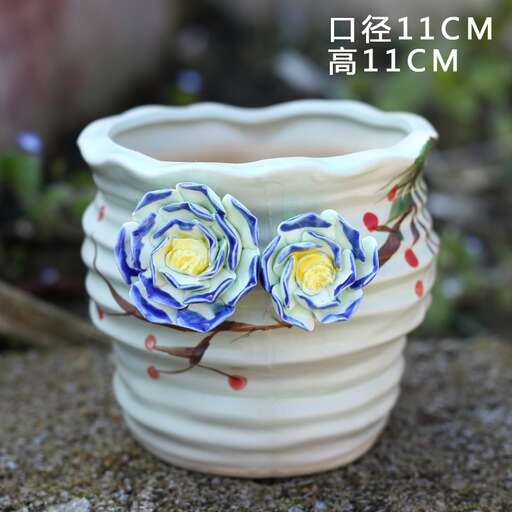 a small ceramic vase with two blue roses on it.