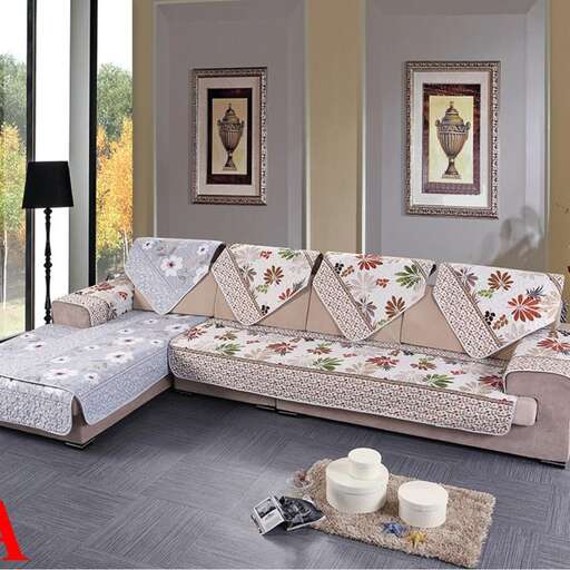 a living room with a couch, ottoman, and a lamp.