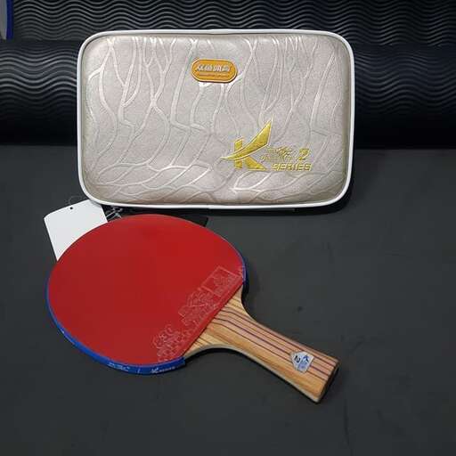 a tennis racket and a bag on a table.