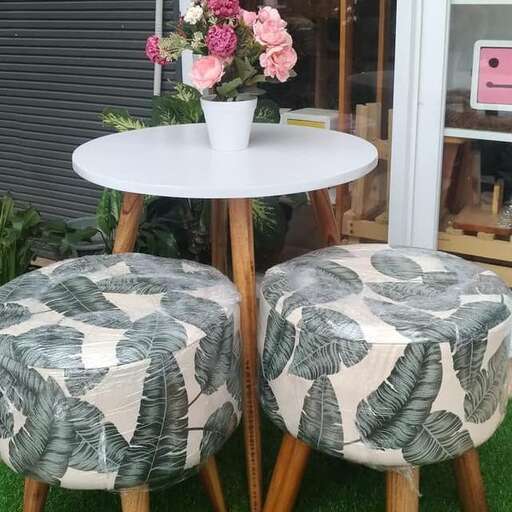 a pair of chairs with a table and flowers.