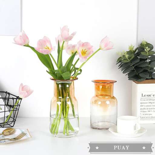a vase with pink flowers on a table.