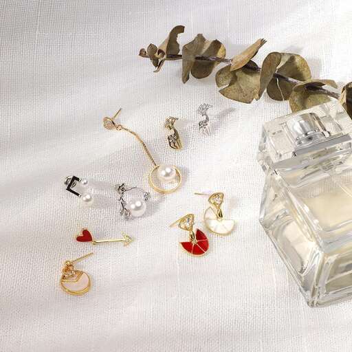 a white table cloth with a gold chain and a glass perfume bottle