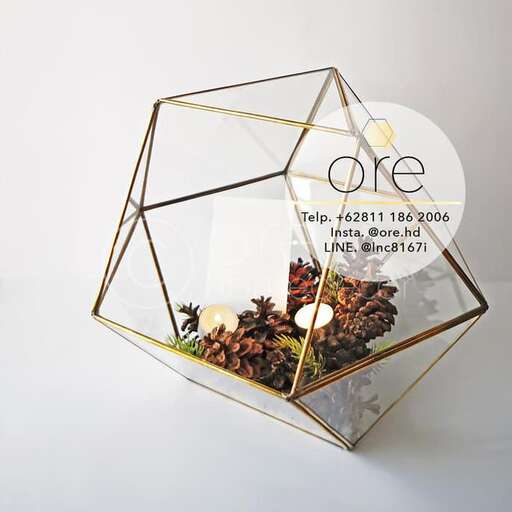 a wire and glass cube with a flower arrangement.