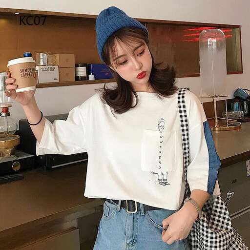 a model in a blue beanie and jeans holding a coffee cup