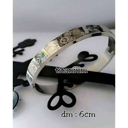 a silver bracelet with a dollar bill on it.