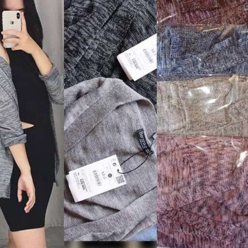 a woman in a black dress and a gray sweater.