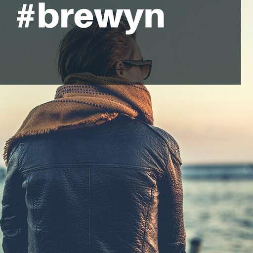 a woman wearing a jacket and sunglasses looking out to sea.