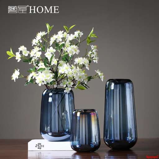 a table with three vases with flowers in them.