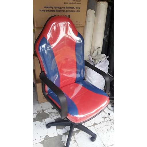 a red and blue chair sitting in a pile of cardboard.
