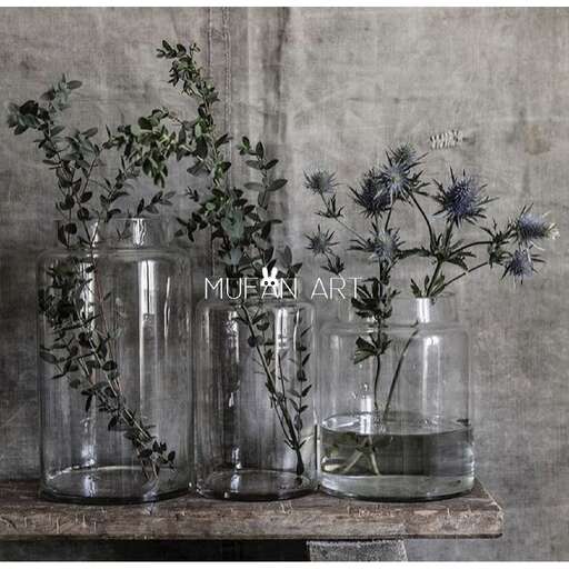 a table with three vases with flowers in them.