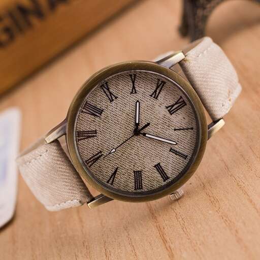 a watch with a strap on a wooden table.