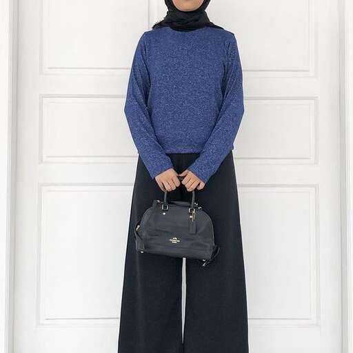 a woman wearing a sweater and a black skirt.