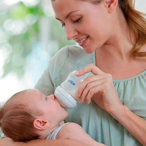 a mother feeding her baby with a bottle