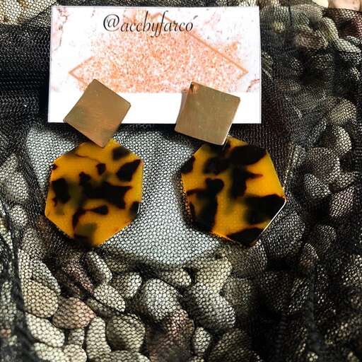 a pair of earrings with a face on a black and white background.