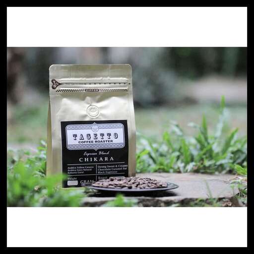 a bag of coffee beans on a stone in the grass