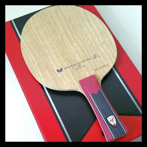 a wooden board with scissors on it and a black and red paper underneath it.