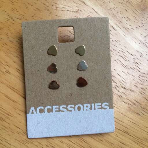 a piece of paper with a few small earrings inside.