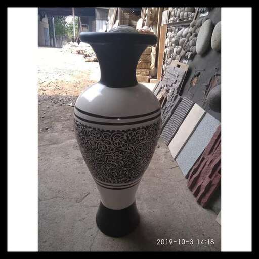 a large vase sitting on the ground outside