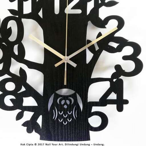 a black clock with a white face and a black owl on it.