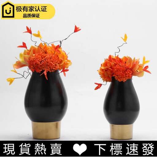 a pair of black vases with orange flowers.