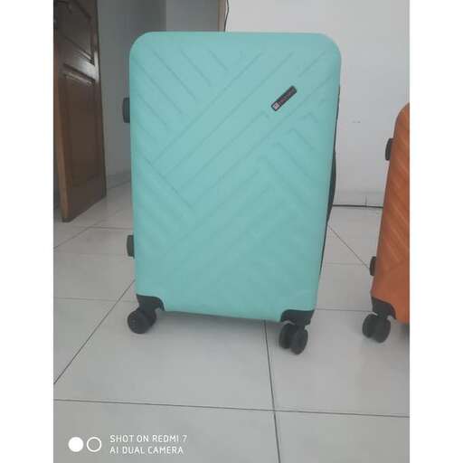 a blue suitcase sitting on a white tiled floor.