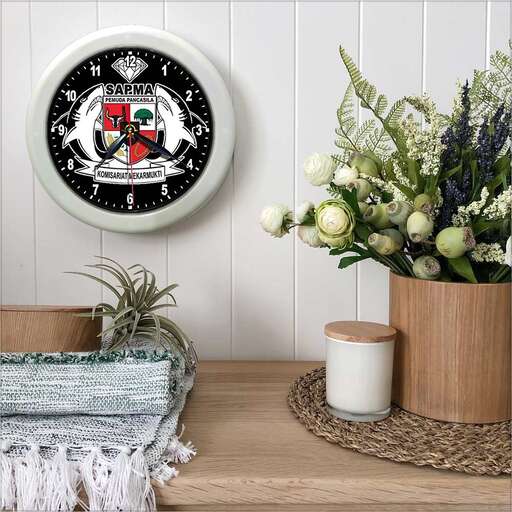 a clock with flowers and a vase of flowers on a table.