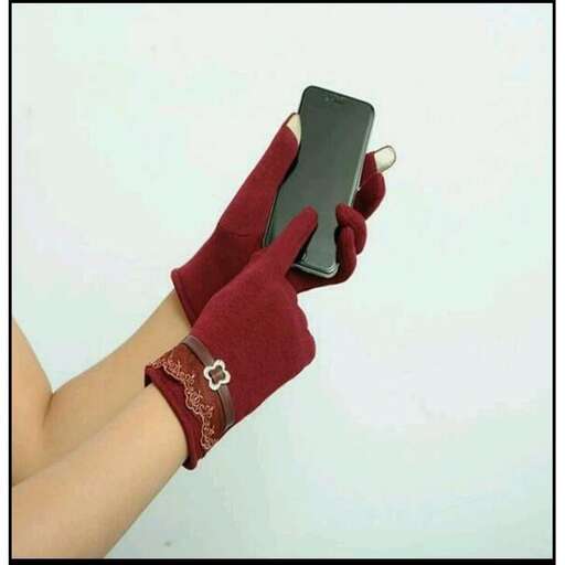 a person wearing a glove holding a cell phone.