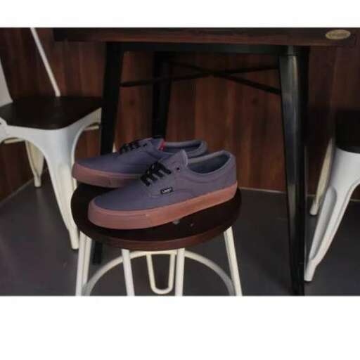 a pair of purple shoes sitting on a stool.