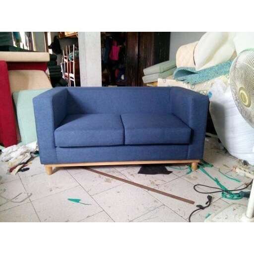 a blue couch sitting on top of a white floor.