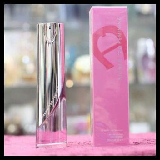 a glass vase with a pink ribbon on it.