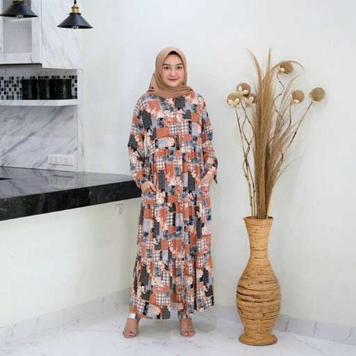 a woman in a patterned dress standing in a room.