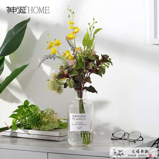 a vase filled with flowers and greenery.