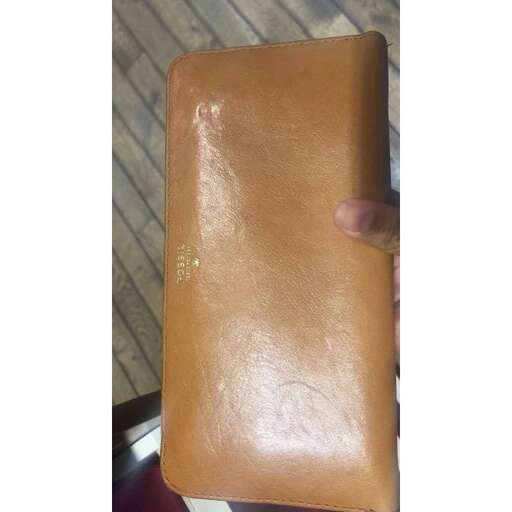 a person holding a brown leather bar in their hand.