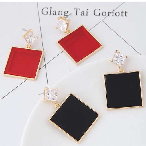 a pair of earrings with a red and black square on the middle.