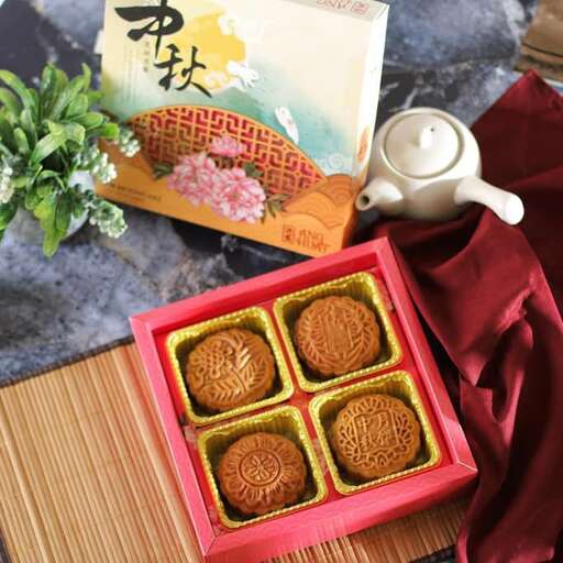 a box of chocolates on a table with a teapot.