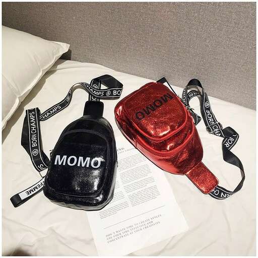 a red water bottle sitting on top of a white sheet.