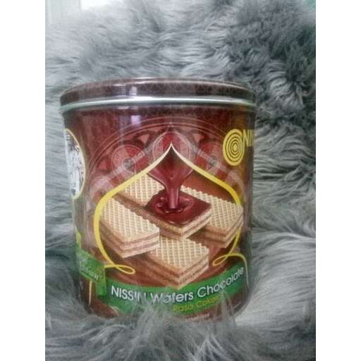 a tin of some sort on a gray rug.