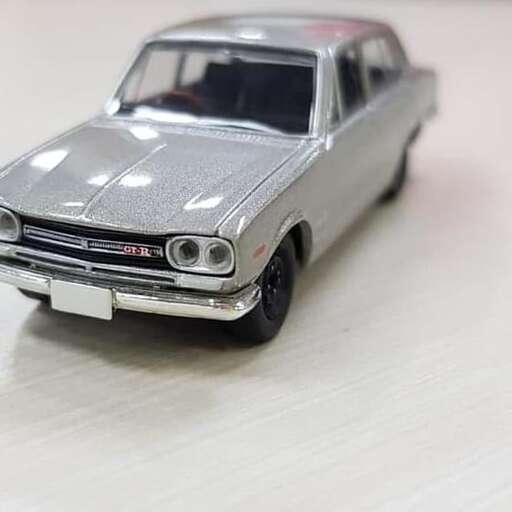 a small silver car on a white table.
