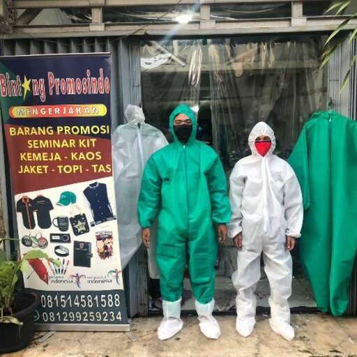 a group of people dressed in green clothes standing in front of a store.