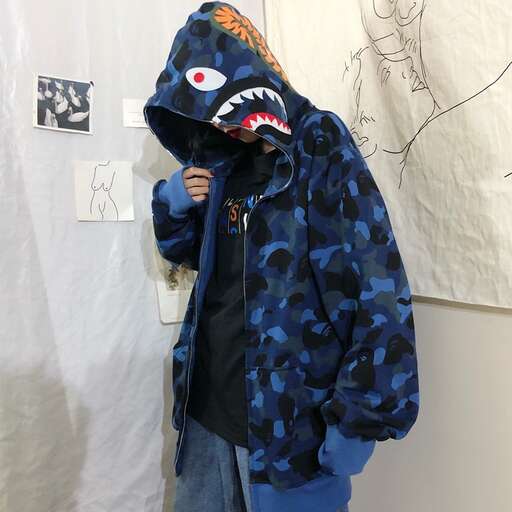 a boy in a blue hoodie with a shark face on it.