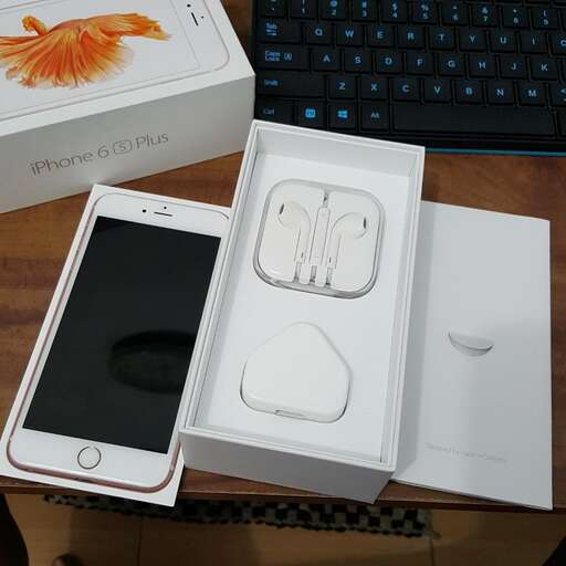 a white apple computer sitting on top of a wooden table.