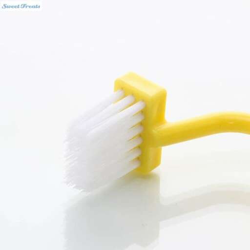a yellow toothbrush with white bristles on a white background.