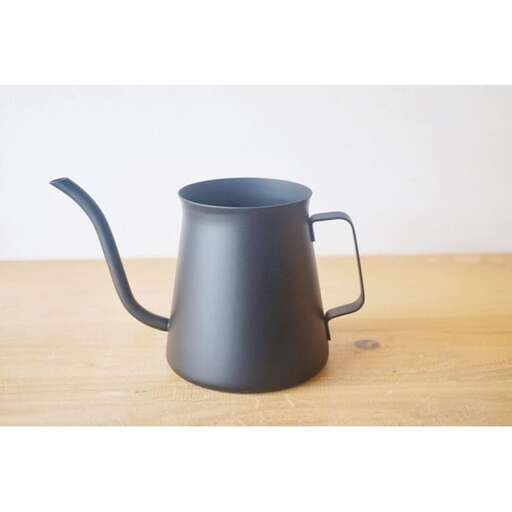 a black metal pitcher with a handle.