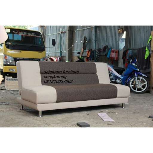 a couch sitting in front of a motorcycle.