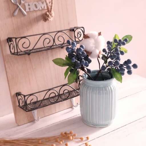a vase with blue berries and a candle in it.